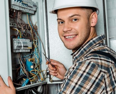 EIn Elektroniker der an einem Verteilerkasten arbeitet